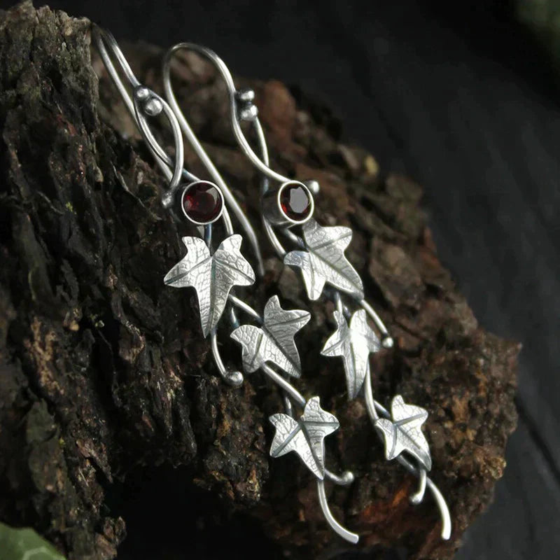 Zilveren oorbellen met klimopblad en blauwe topaas