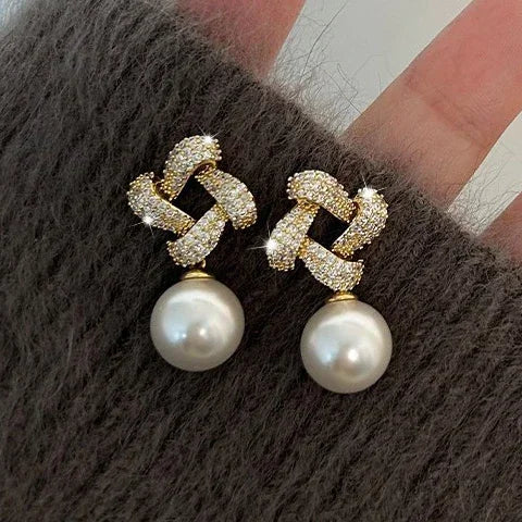 Gouden oorbellen met kristallen knoop en parelhanger