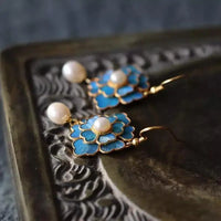 Gouden bloemoorbellen met blauw emaille en parel