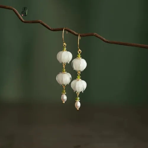Gouden oorbellen met witte glaskralen en parel