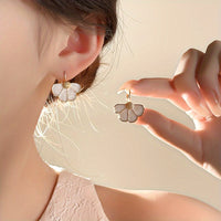 Gouden oorbellen met witte parelmoer bloem