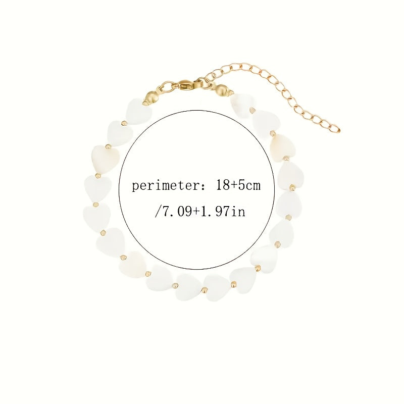 Gouden armband met witte parelmoer hartjes