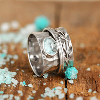 Zilveren spinner-ring met aquamarijn en bladmotief