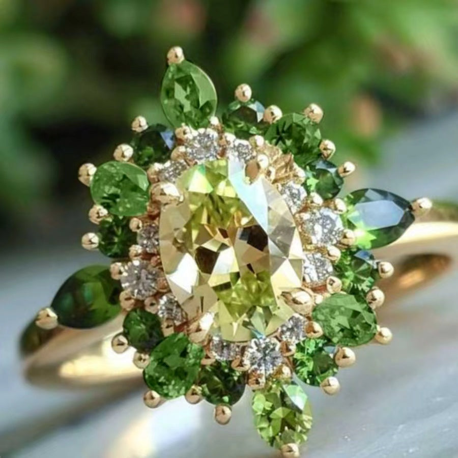Gouden ring met groene edelstenen en halo