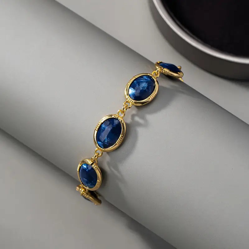 Gouden armband met blauwe ovale edelstenen
