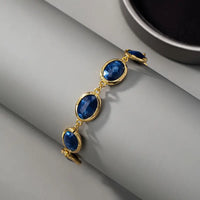 Gouden armband met blauwe ovale edelstenen