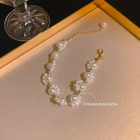 Gouden armband met parelclusters en hangbedeltje