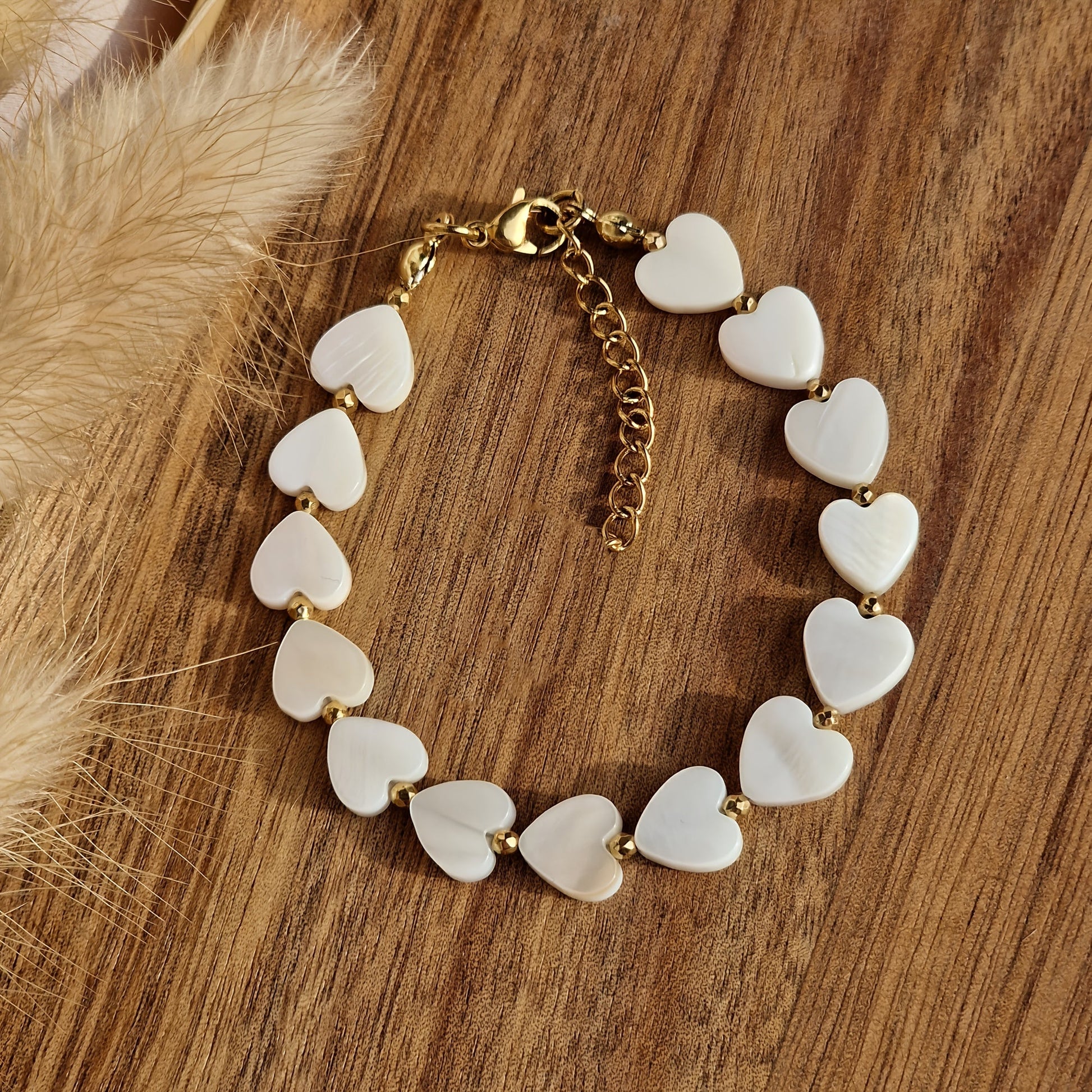 Gouden armband met witte parelmoer hartjes