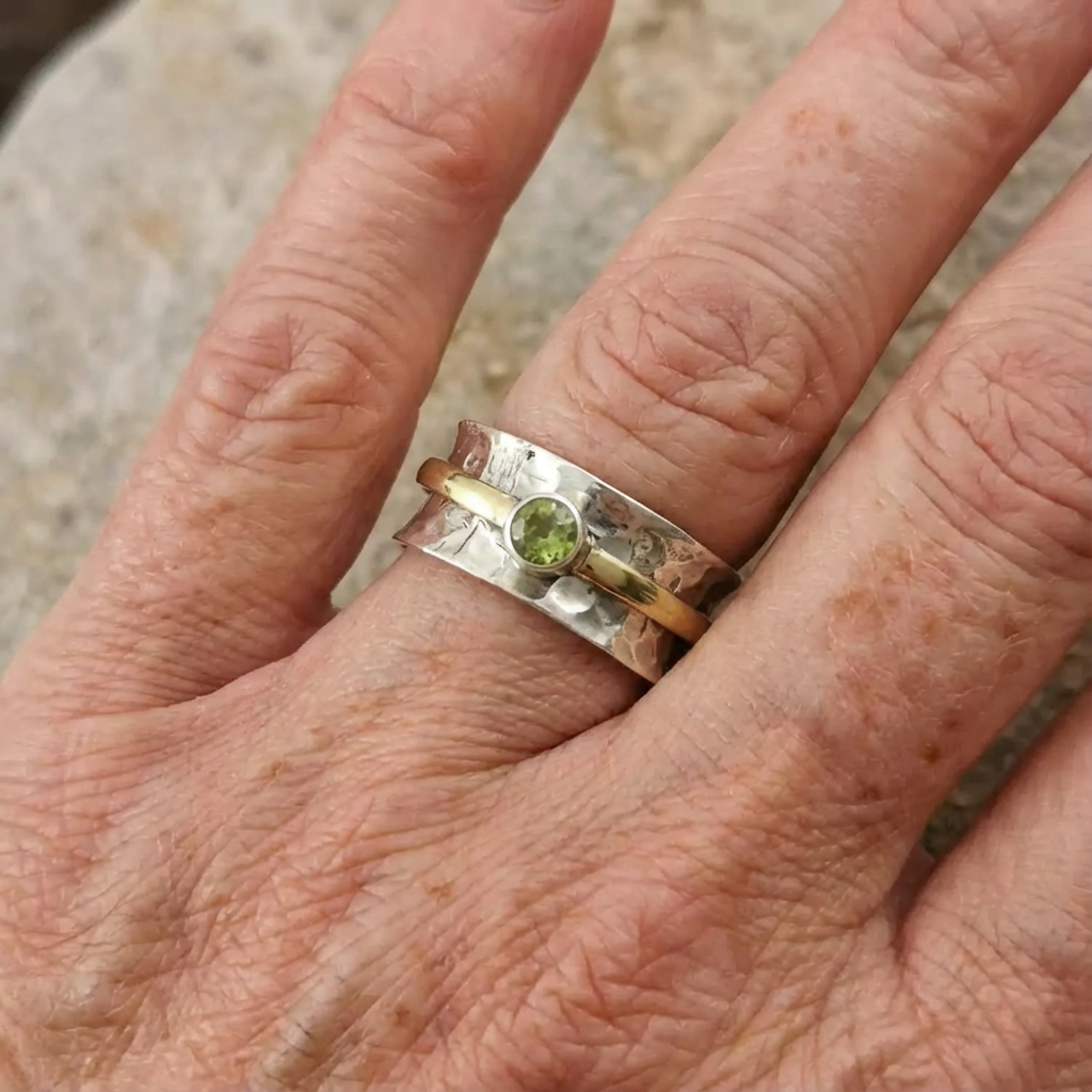 Zilver-gouden gehamerde spinner ring met peridoot