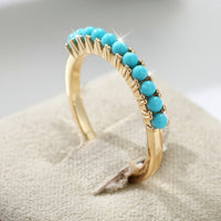 Gouden ring met rij turquoise kralen
