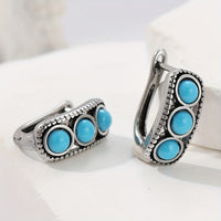 Zilveren huggie oorbellen met drie turquoise stenen