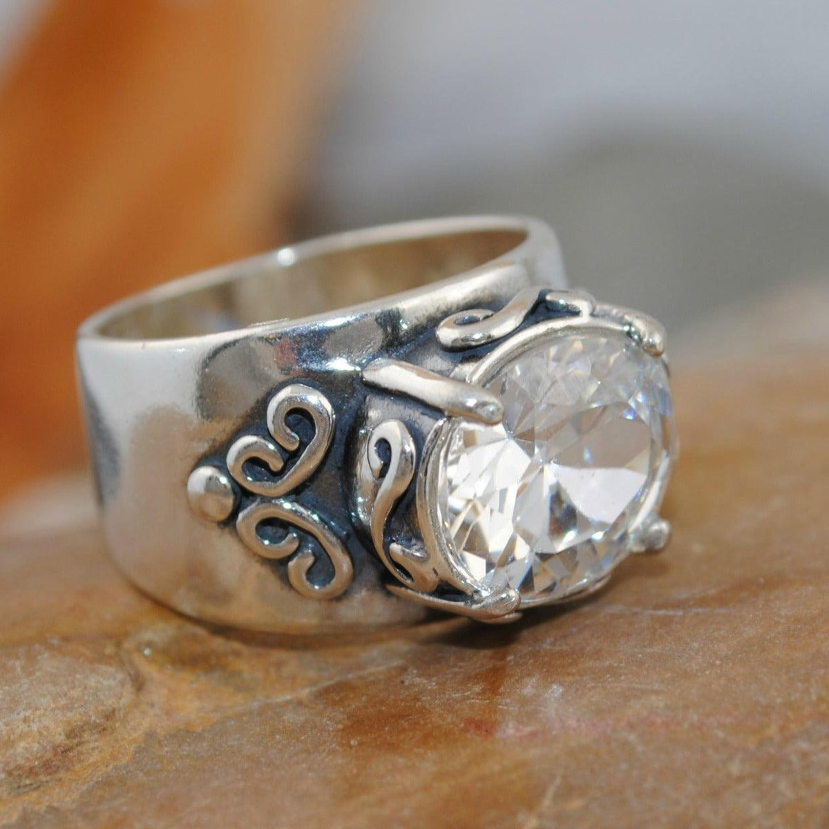 Zilveren ring met ovale zirkonia en sierlijk krulwerk