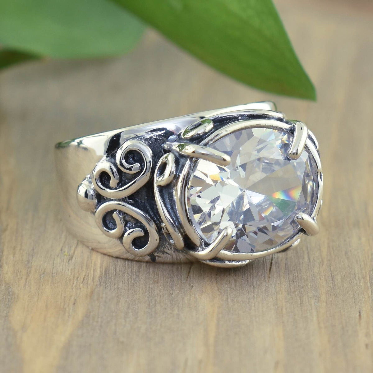 Zilveren ring met ovale zirkonia en sierlijk krulwerk