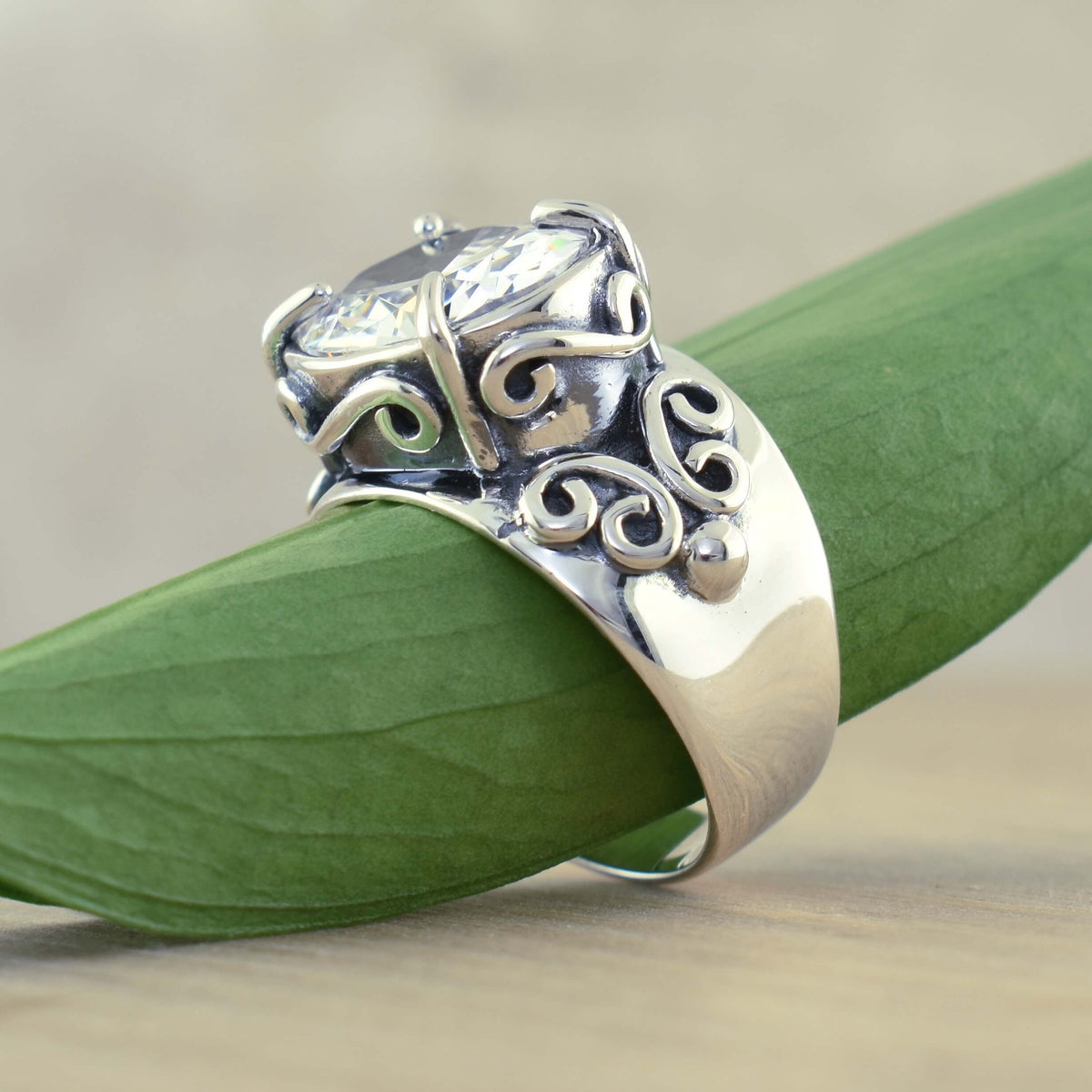 Zilveren ring met ovale zirkonia en sierlijk krulwerk