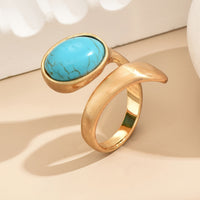 Gouden bypass ring met ovale turquoise steen