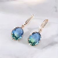 Gouden oorbellen met ovale blauwgroene steen