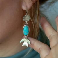 Zilveren oorbellen met ovale turquoise en vogelhanger