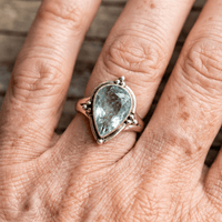 Gouden ring met peervormige lichtblauwe edelsteen