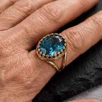 Gouden vintage ring met ovale blauwe edelsteen in kroonzetting