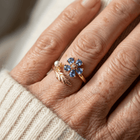 Gouden open ring met blauwe bloem, parel en blad