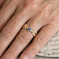 Gouden ring met blauwe steen en bladmotief