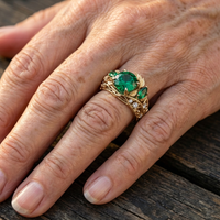 Gouden ring met groene edelsteen en bladmotief