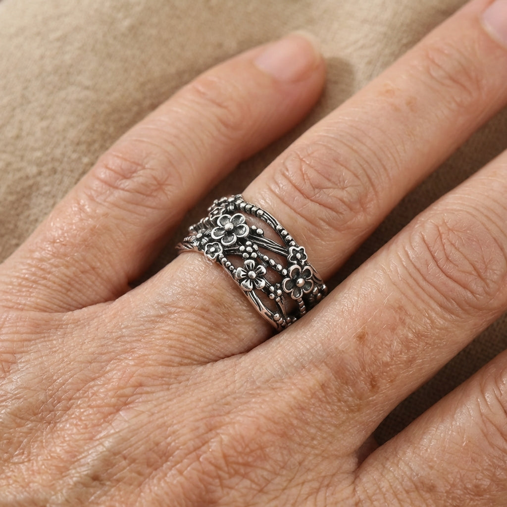 Zilveren brede ring met bloemmotief in oxidatie