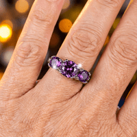 Zilveren ring met rij paarse edelstenen