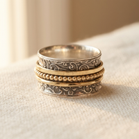 Zilveren en gouden spinner ring met sierlijk patroon