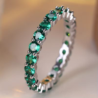 Gouden eternity-ring met groene edelstenen