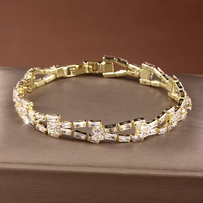 Gouden armband met groene en heldere edelstenen
