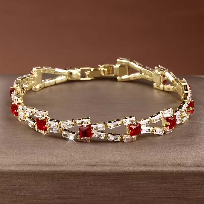 Gouden armband met groene en heldere edelstenen