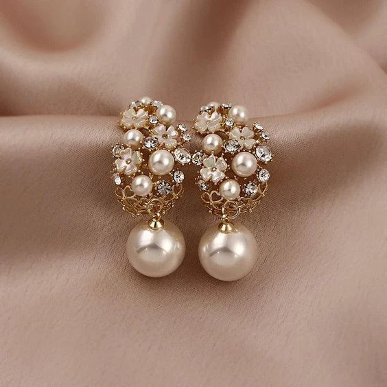 Gouden oorbellen met bloem van strass en parelhanger