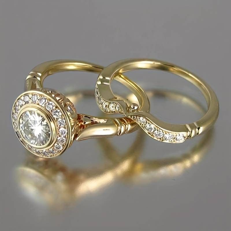 Gouden ringenset met ronde zirkonia in halo en gebogen band