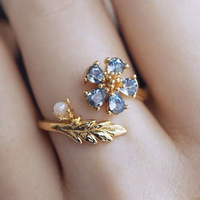 Gouden open ring met blauwe bloem, parel en blad