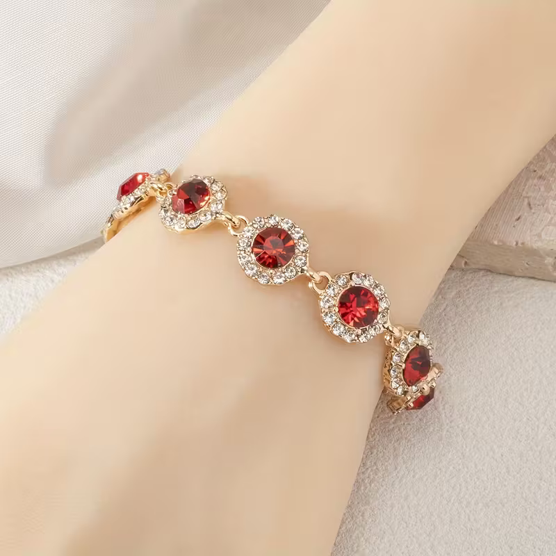 Gouden armband met rode zirkonia steentjes
