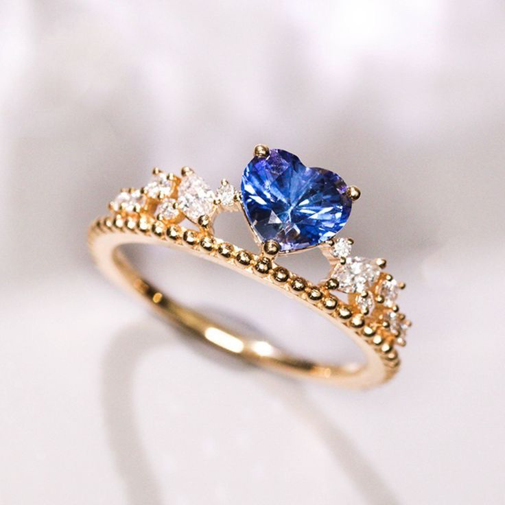 Gouden ring met blauwe ovale steen en tiaramotief