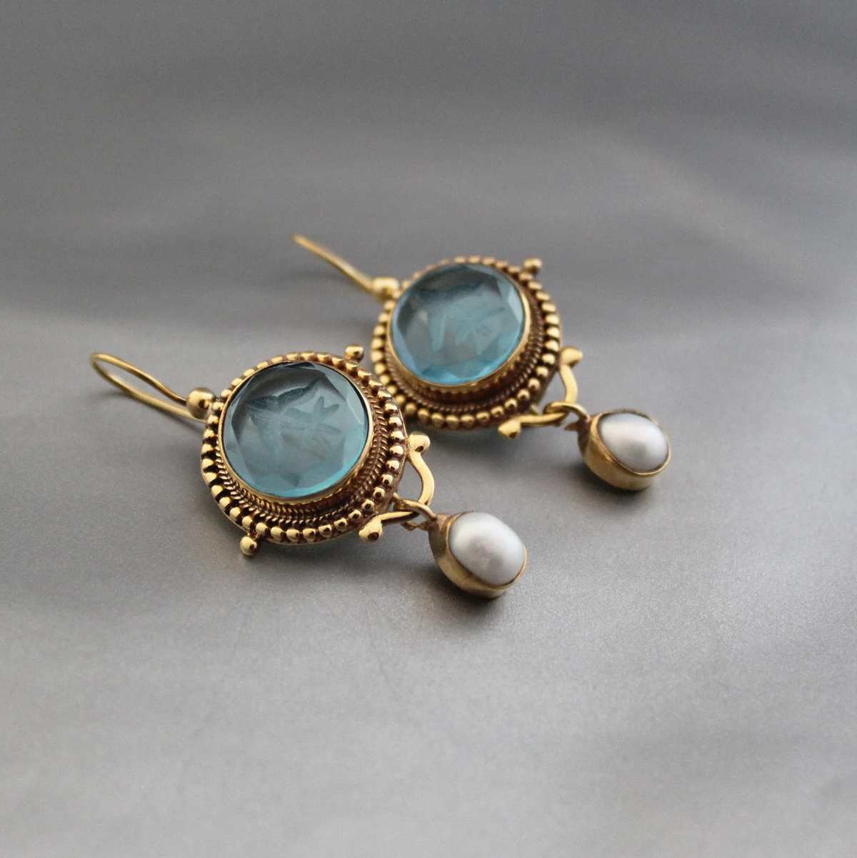 Gouden vintage oorbellen met blauw glas en parel