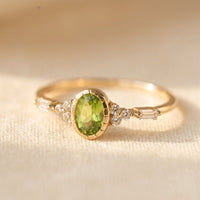 Gouden ring met ovale peridoot en baguette-diamant