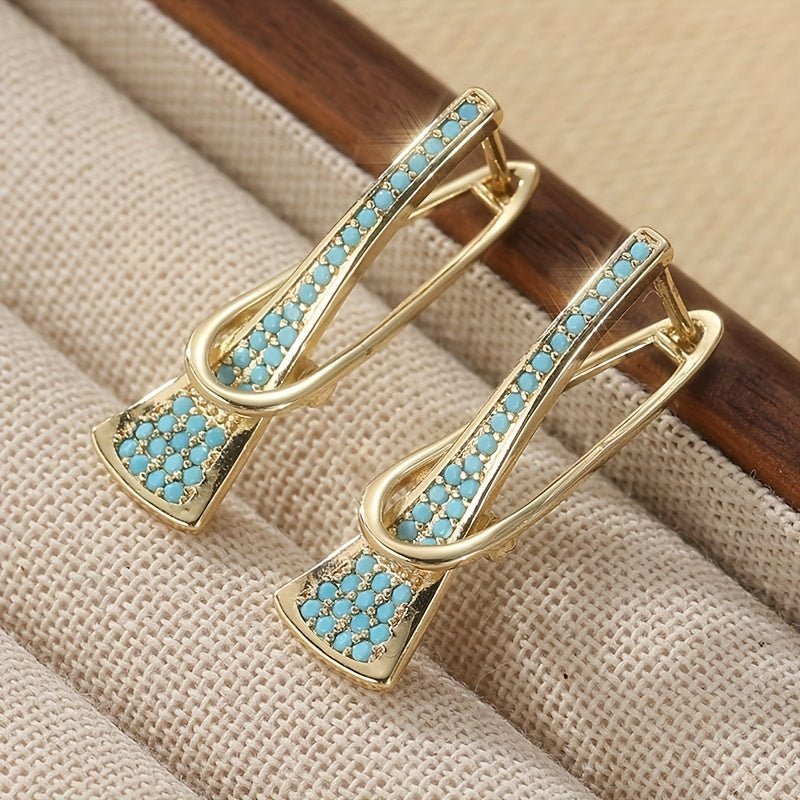 Gouden oorbellen met turquoise en gekruist design