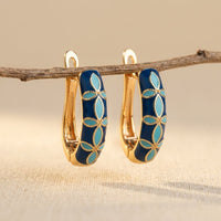 Gouden oorbellen met blauwe en turquoise emaille bloemen