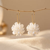 Gouden oorbellen met witte bloemhanger