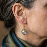 Gouden vintage oorbellen met aquablauwe glaskraal