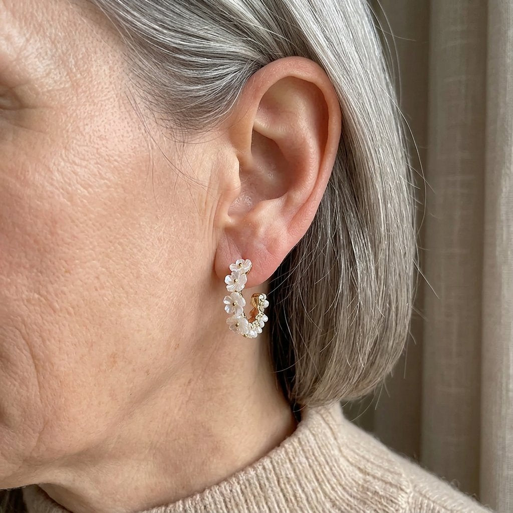 Gouden oorbellen met witte parelmoer bloemen