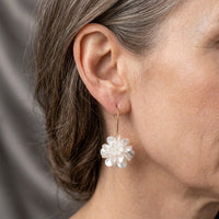 Gouden oorbellen met witte bloemhanger