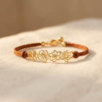 Bruine koord armband met gouden bloemen