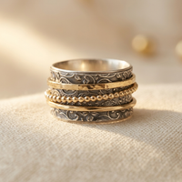 Zilveren en gouden spinner ring met sierlijk patroon