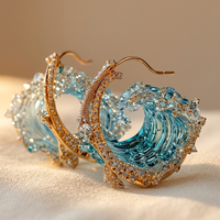 Gouden oorbellen met blauwe golf en kristallen